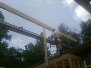 Carpenter setting a ridge beam over a new addition frame — Ice Dam Removal by Roofing Brothers in Elberta