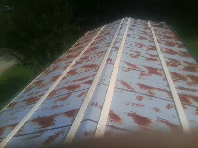 Rusted metal roof panels with new wood purlins before replacement — Storm Damage Roof Repair in Elberta by Roofing Brothers