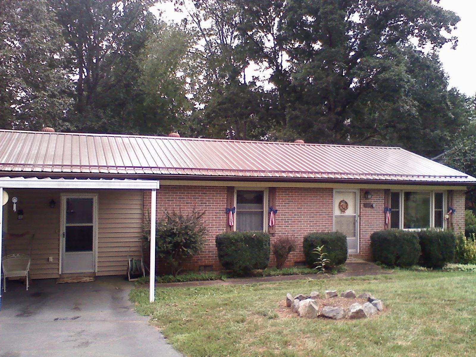 Bronze metal roof and carport on a brick ranch home — Roof Repair work by our crew in Elberta